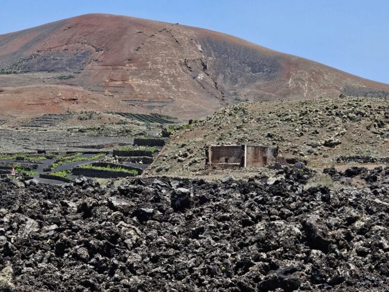 Timanfaya (15) roche volcanique et volcan au loin près du centre des visiteurs de timanfaya